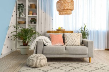 Gri kanepesi, penceresi ve raf ünitesi olan oturma odası.