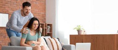 Kızgın kocasıyla evde ağlayan hamile bir kadın. Aile içi şiddet kavramı