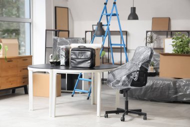 Taşınma gününde masa, kutu ve merdiven ile ofis içi