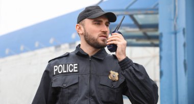 Erkek polis memuru şehir sokaklarında devriye geziyor.