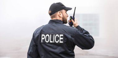 Erkek polis memuru şehir sokaklarında devriye geziyor.