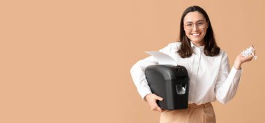 Sekreter kağıt öğütücüsünü bej arkaplanında tutuyor ve metin için boşluk var