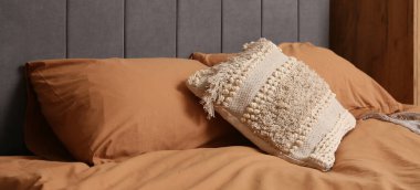 Yatak odasında yastıklar olan büyük, rahat bir yatak.