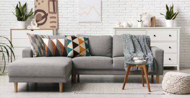 Oturma odasında şık yastıkları olan gri kanepe.