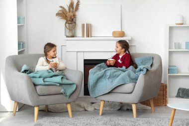 Evde oturup çay içen tatlı küçük kızlar.