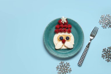 Mavi arka planda Noel Baba şeklinde gözleme tabağı. Noel kutlaması