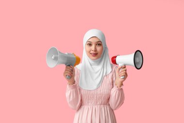 Pembe arka planda megafonları olan genç Asyalı Müslüman kadın. Ulusal Duyulma Günü