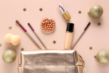Bej arka planda güzel Noel süslemeleri ve makyaj ürünleri. Üst görünüm