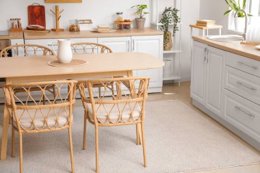 Modern mutfağın içinde yemek masası ve sandalyeler.