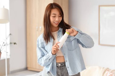 Evinde lezzetli yoğurt şişesiyle güzel bir Asyalı kadın.