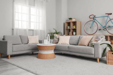 Koltuklar, kahve masası, raf ünitesi ve bisiklet oturma odasının içinde.