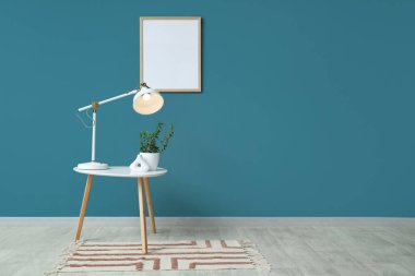 Parlak masa lambalı kahve masası ve mavi duvarın yanında bitkiler.