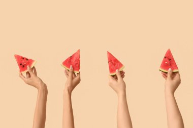 Bej arka planda tatlı karpuz parçaları olan kadın elleri.