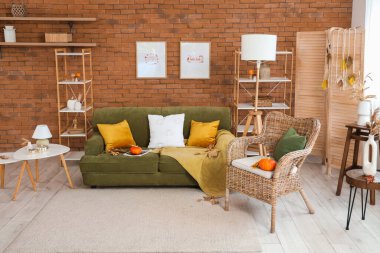 Oturma odasının sonbaharında kabaklı rahat bir kanepe ve koltuk.