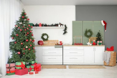 İçinde Noel ağaçları, beyaz tezgahlar ve katlanan perdeler olan mutfağın içi.
