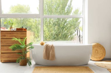 Banyonun içinde küvet, çekmece ve palmiye ağaçları var.