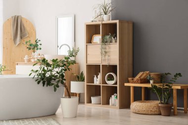 Banyonun içinde küvet, raf ünitesi ve ahşap bank var.