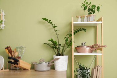 Mutfağın içinde tezgah, raf ünitesi ve mutfak gereçleri var.