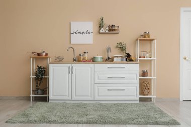 Mutfağın içi tezgah, raf üniteleri ve çatal bıçaklarla dolu.