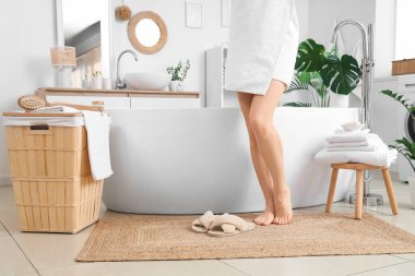 Banyoda hasır üzerinde çıplak ayaklı kadın.