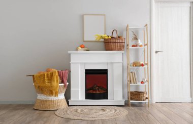 Şömineli, sonbahar dekorlu ve raf üniteli bir aydınlatma odası.