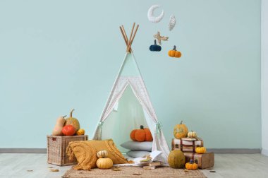 Çocuk odasının içinde oyun çadırı ve balkabağı var.