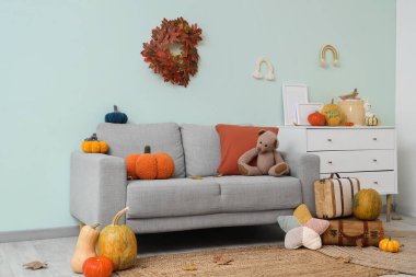 Çocuk odasının içinde kanepe, çekmece ve balkabağı var.