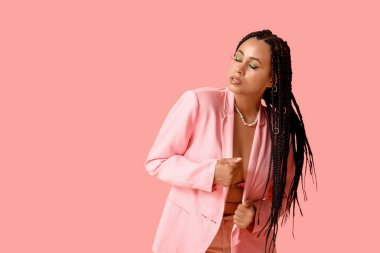 Pembe arka planda örgüleri olan seksi Afro-Amerikan kadın.