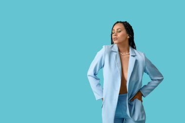 Mavi arka planda örgüleri olan seksi Afro-Amerikan kadın.