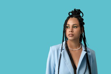 Mavi arka planda örgüleri olan şık, Afro-Amerikan bir kadın.