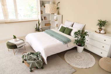 Rahat yatak, raf ünitesi, çekmece sandığı, yatak odasının iç tarafında ekose ve sepet.