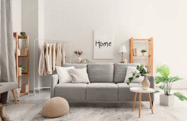 Elbise askısı, kanepe ve raf üniteleriyle oturma odasının içinde.