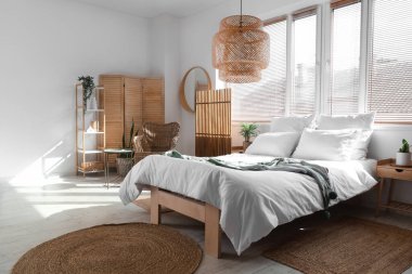 Konforlu yatak odası, koltuk ve katlanır ekran.