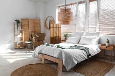 Konforlu yatak odası, koltuk ve katlanır ekran.