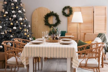 Masası, Noel ağacı ve çelengi olan yemek odasının içi.
