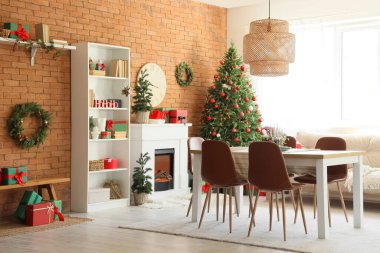 Yemek odasının içinde masa, şömine ve Noel ağaçları var.