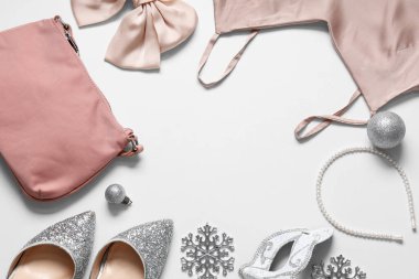 Beyaz arka planda şık kıyafetler, aksesuarlar ve Noel dekorundan yapılmış çerçeve