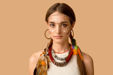 Bej arka planda Hint kostümü giymiş güzel bir genç kadın. Yerli Amerikan Mirası Ayı