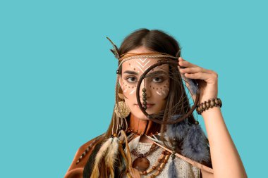Mavi arka planda düş kapanı olan Kızılderili kostümlü güzel bir kadın. Yerli Amerikan Mirası Ayı