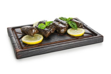 Lezzetli Dolmas tahtasıyla (doldurulmuş üzüm yaprakları) ve beyaz arka planda limon dilimleri