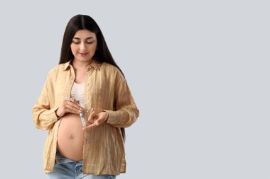 Gebelik diyabeti olan genç hamile bir kadın arka planda tükenmez kalem kullanıyor.