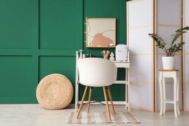 Aynalı, masalı ve katlanır ekranlı şık bir makyaj odası.