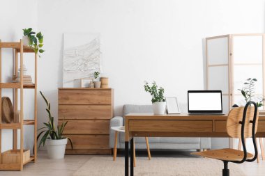 Oturma odasındaki programcının masasına çerçeveli boş bir dizüstü bilgisayar.