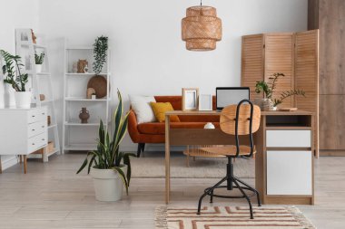 Programcının işyeri, kanepesi ve bitkileriyle oturma odasının içinde.