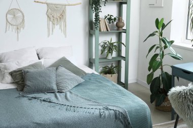 Yatak odasının içi rahat yatak ve çiçeklerle dolu.