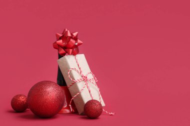 Kırmızı arka planda Noel topları ve hediye kutusu olan güzel bir kompozisyon