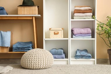 Katlanmış elbiseli ve dekorlu raflar.