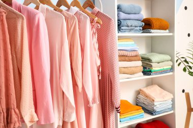 Soyunma odasında elbise ve askılar var.