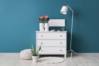 Klozette vazolarda lamba ve protea çiçekleri olan odanın içi.