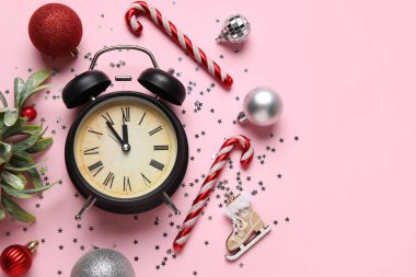 Alarmlı saat kompozisyonu ve pembe arka planda farklı Noel dekorasyonu